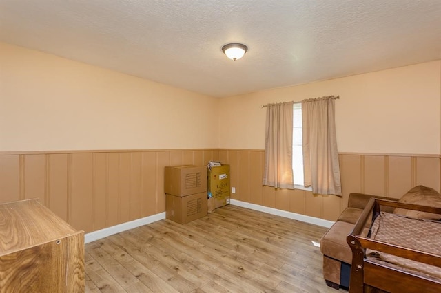 living area featuring a textured ceiling and hardwood / wood-style floors