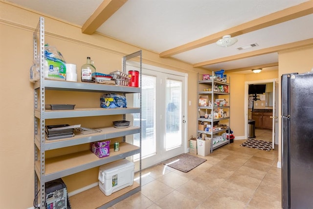 kitchen featuring black fridge and light tile floors