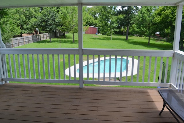 wooden deck with a fenced in pool, a storage shed, and a lawn