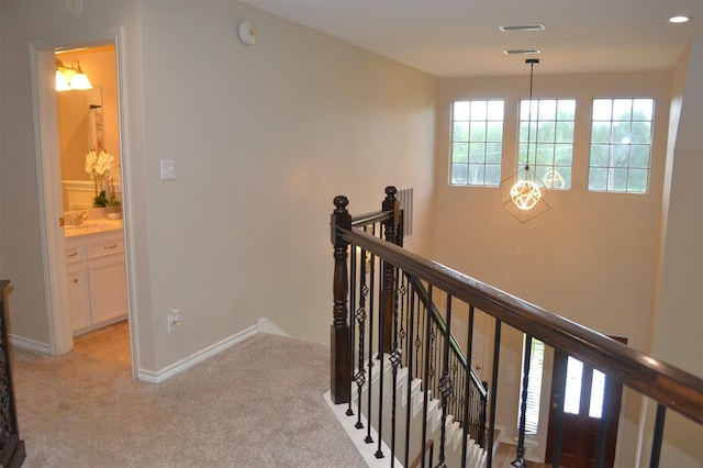 hallway with light colored carpet and sink