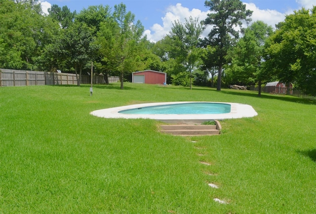 view of pool featuring a lawn and an outbuilding