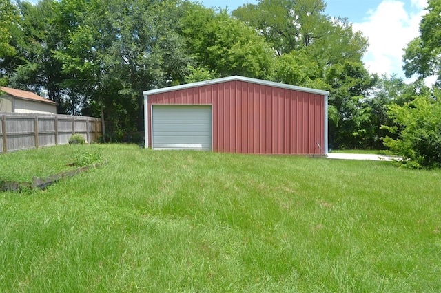 view of outdoor structure featuring a garage and a lawn