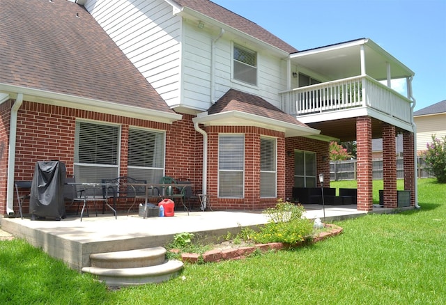 rear view of house featuring a yard, a patio, and a balcony