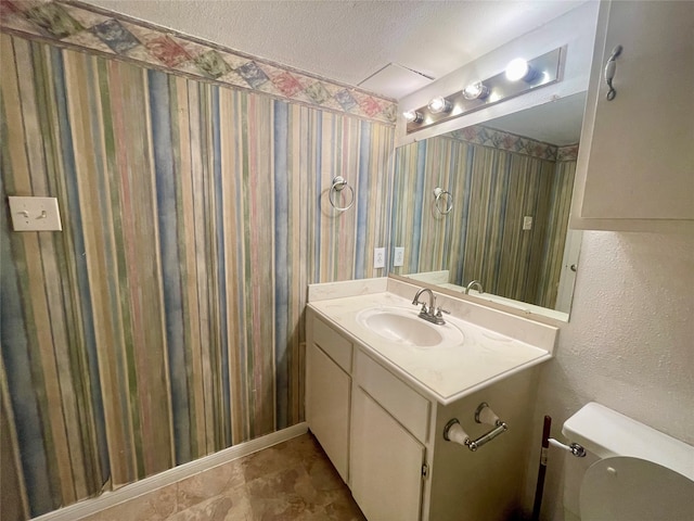 bathroom with vanity, a textured ceiling, and toilet