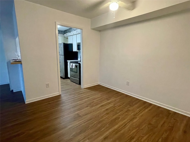 empty room with dark hardwood / wood-style flooring and ceiling fan