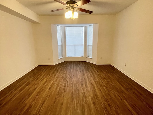 spare room featuring ceiling fan and dark wood-type flooring