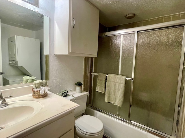 full bathroom with vanity, bath / shower combo with glass door, a textured ceiling, and toilet