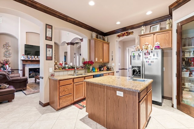 kitchen featuring light stone countertops, sink, a center island with sink, and crown molding