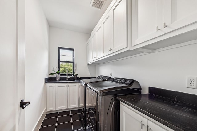 laundry room featuring cabinets, sink, dark tile patterned flooring, and washing machine and clothes dryer