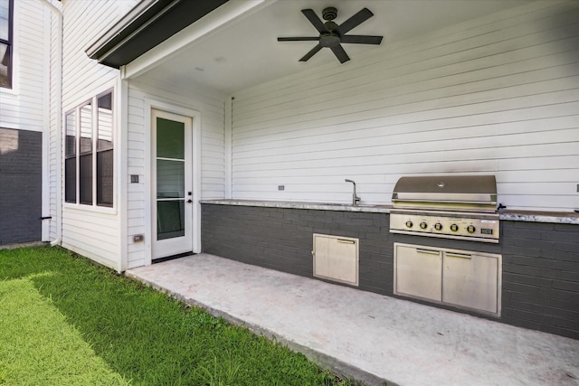 view of patio / terrace featuring ceiling fan, a grill, exterior kitchen, and sink