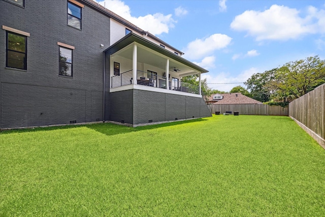 view of yard with ceiling fan and a balcony