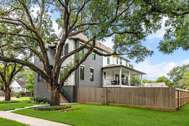 view of side of property with a balcony and a yard