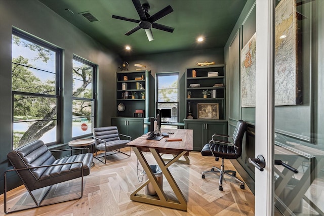 home office with ceiling fan, a wealth of natural light, and light parquet flooring