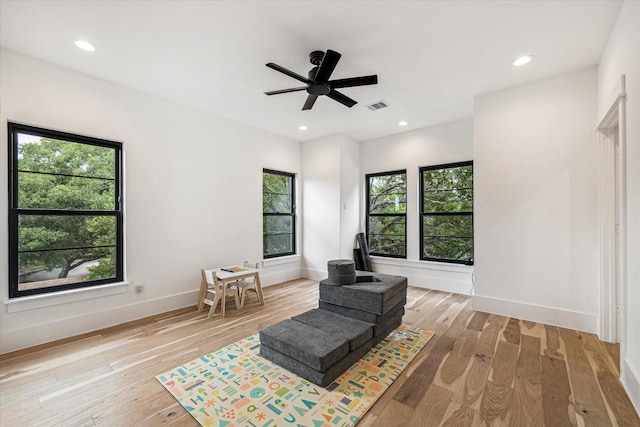 living room with ceiling fan and light hardwood / wood-style flooring