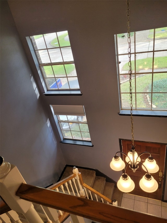 staircase featuring an inviting chandelier and a towering ceiling