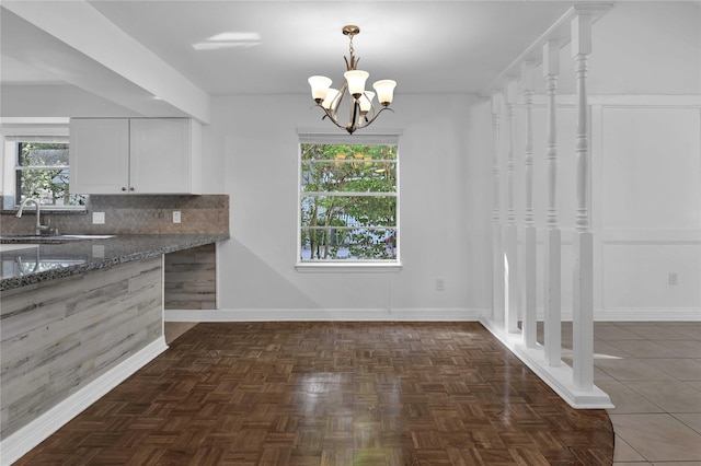 unfurnished dining area with sink and a chandelier