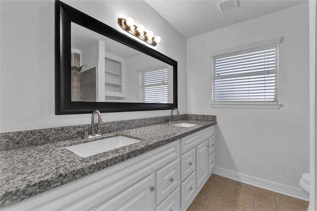 bathroom featuring vanity, a shower, tile patterned floors, and toilet