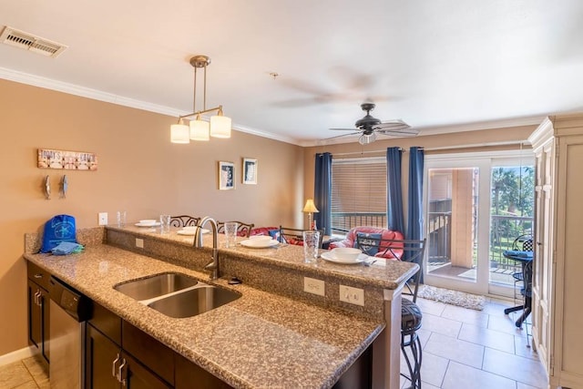 kitchen featuring sink, a breakfast bar area, light stone counters, crown molding, and stainless steel dishwasher