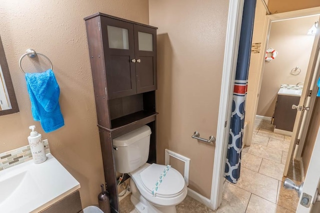 bathroom featuring vanity, tile patterned floors, and toilet