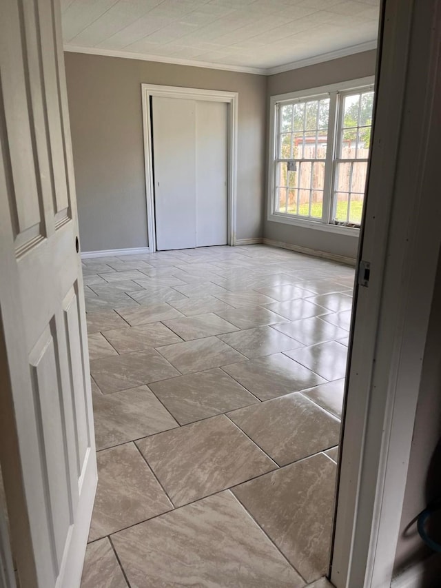 unfurnished bedroom with crown molding and a closet