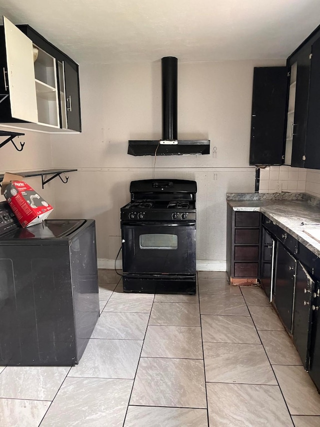 kitchen featuring black gas range, ventilation hood, washer / clothes dryer, and light tile patterned flooring