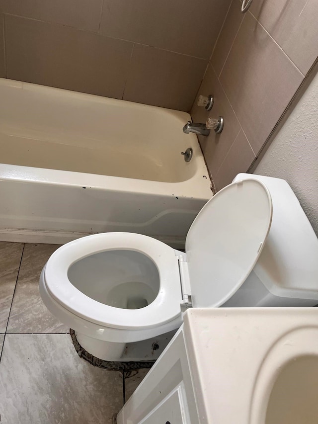 bathroom with a washtub and toilet