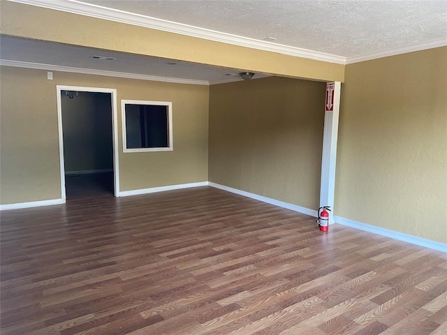 empty room with a textured ceiling, wood-type flooring, and ornamental molding