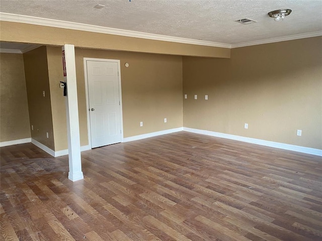 empty room with dark hardwood / wood-style flooring, a textured ceiling, and crown molding