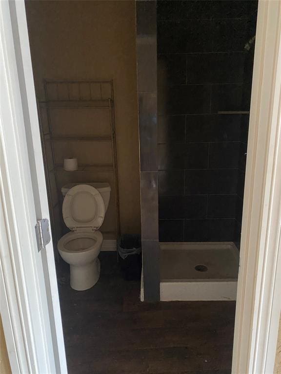 bathroom featuring a shower, wood-type flooring, and toilet