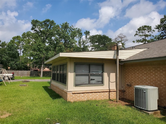 view of property exterior with a lawn and central AC unit