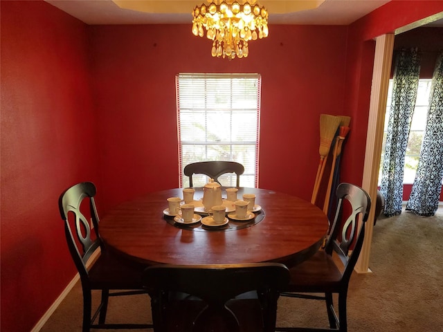 dining space with carpet and an inviting chandelier