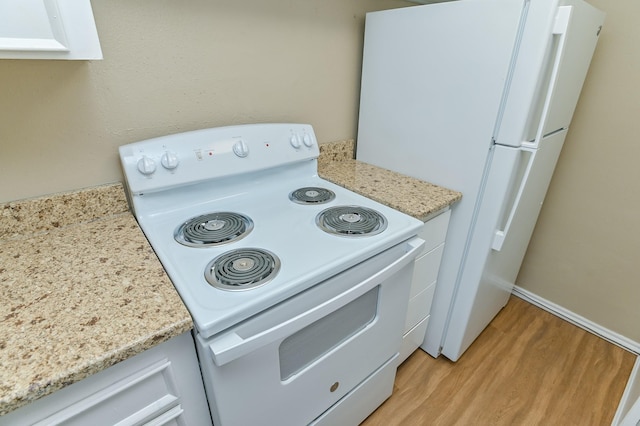 kitchen featuring light wood-type flooring, white appliances, white cabinetry, and light stone countertops