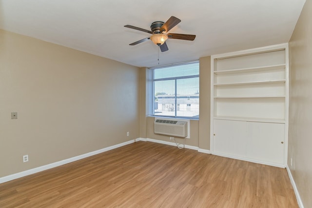 unfurnished bedroom featuring ceiling fan, light wood-type flooring, and an AC wall unit