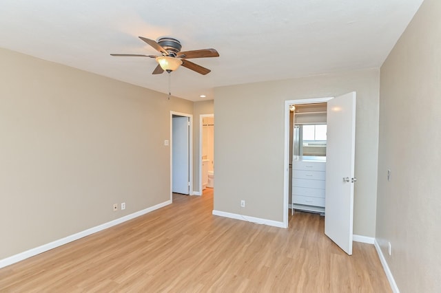 unfurnished bedroom featuring light hardwood / wood-style floors, ensuite bath, and ceiling fan