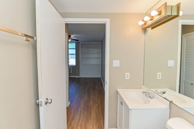 bathroom with vanity, hardwood / wood-style flooring, toilet, and ceiling fan