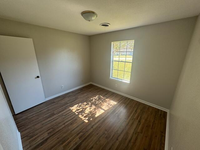 unfurnished room with dark hardwood / wood-style floors