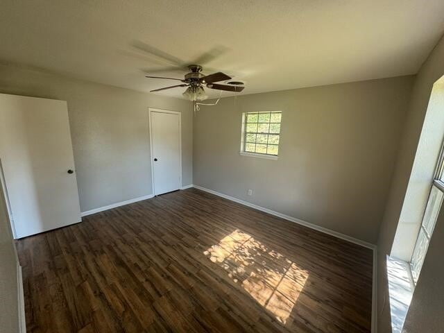 empty room featuring dark hardwood / wood-style floors and ceiling fan