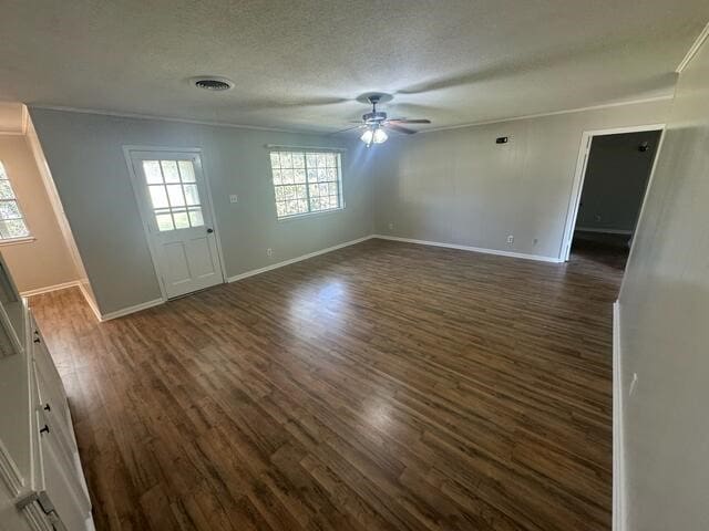 interior space featuring ceiling fan, dark hardwood / wood-style flooring, a textured ceiling, and ornamental molding