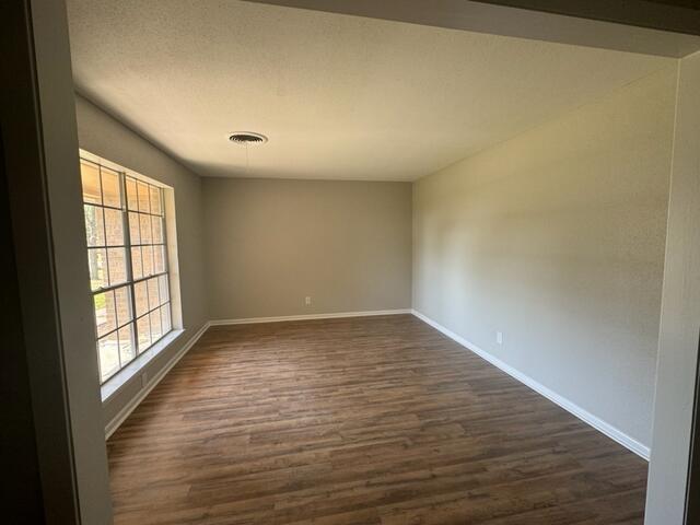 empty room with dark wood-type flooring