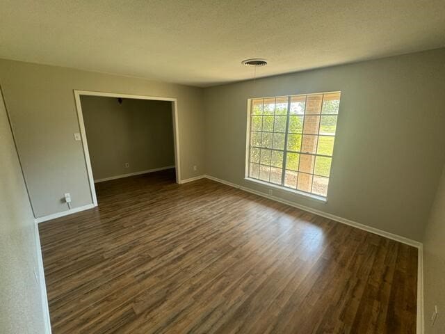 empty room with dark hardwood / wood-style flooring