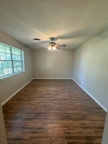 unfurnished room with ceiling fan and dark wood-type flooring