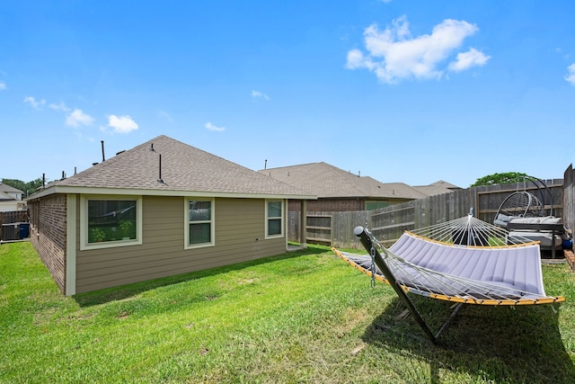 back of house featuring a lawn and central air condition unit