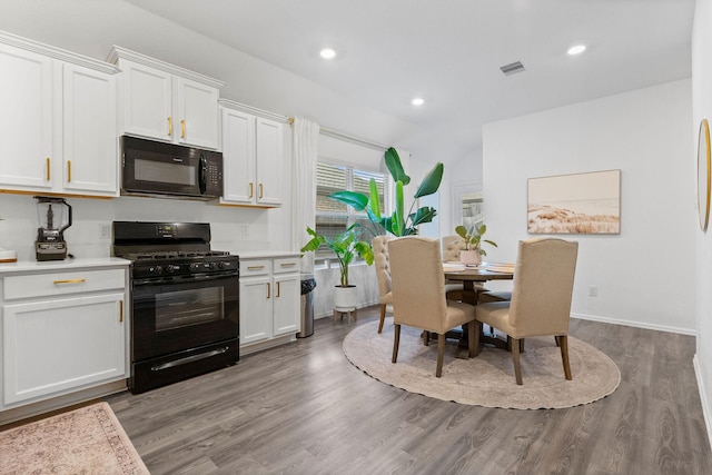 kitchen featuring white cabinetry, black appliances, and wood-type flooring