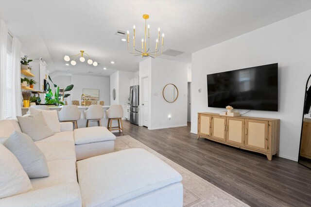 living room with a notable chandelier and dark wood-type flooring