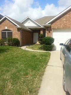 ranch-style home with a garage and a front yard