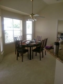 dining room featuring carpet, ceiling fan, and lofted ceiling