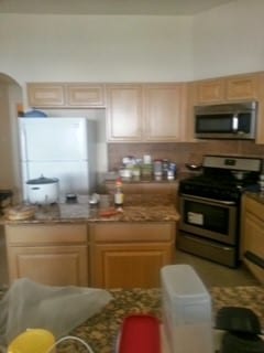 kitchen with stainless steel appliances and light brown cabinetry