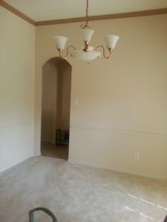 carpeted empty room featuring crown molding