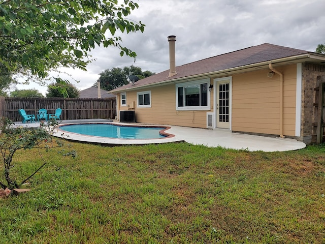 view of pool with a patio, central air condition unit, and a lawn