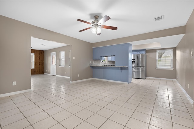 unfurnished living room featuring ceiling fan and light tile patterned floors